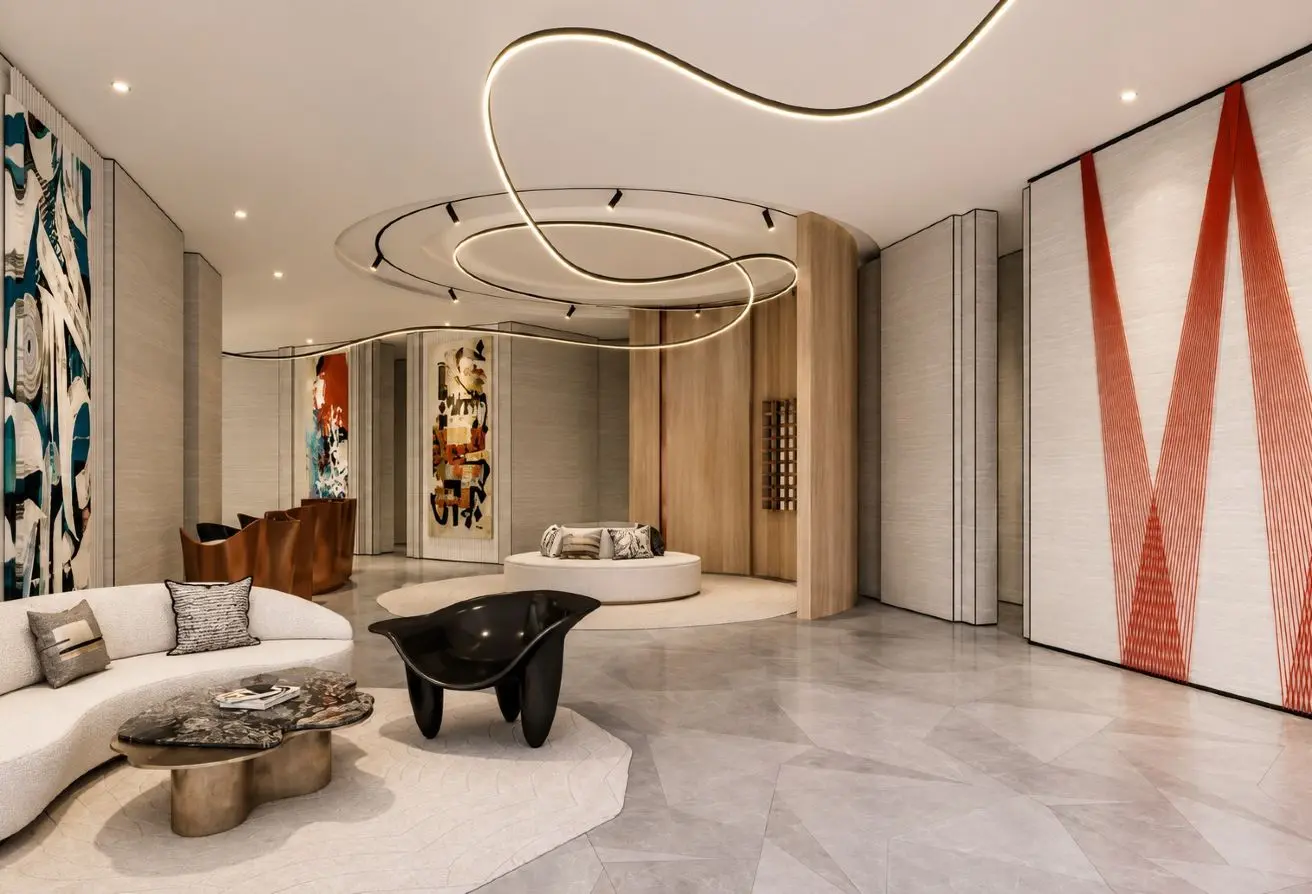Luxurious hotel lobby with curved white sofa, black sculpture table, and circular ceiling light art installation.