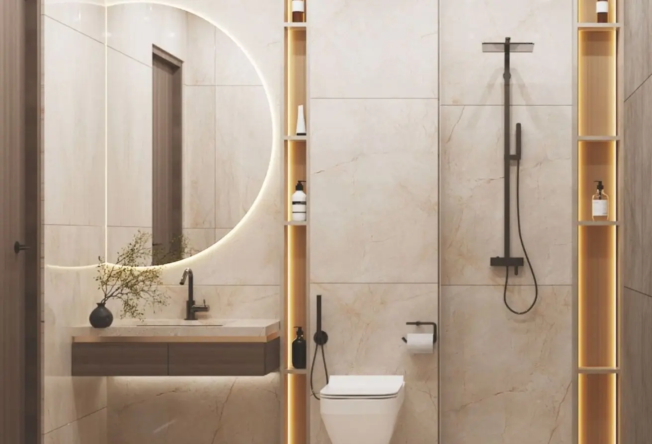 Modern bathroom with a circular backlit mirror above a marble vanity, black faucet, and wooden cabinet.