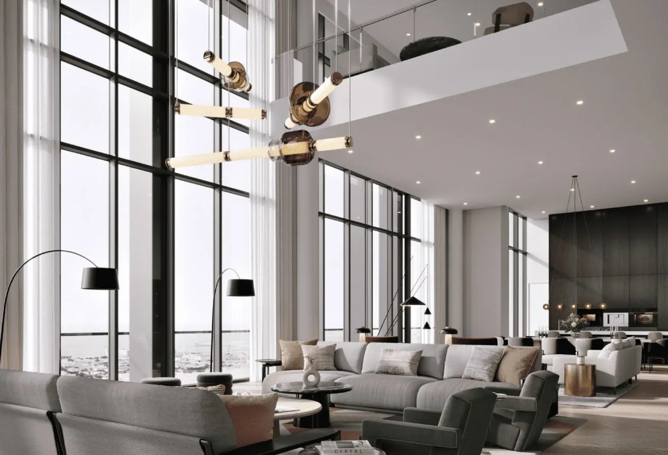 Open, sunlit hotel lobby with large floor-to-ceiling windows, gray seating, and a sculptural chandelier.