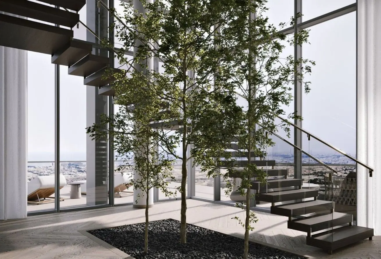 Modern living space with indoor trees inside a glass-walled room and a floating staircase overlooking a city skyline.