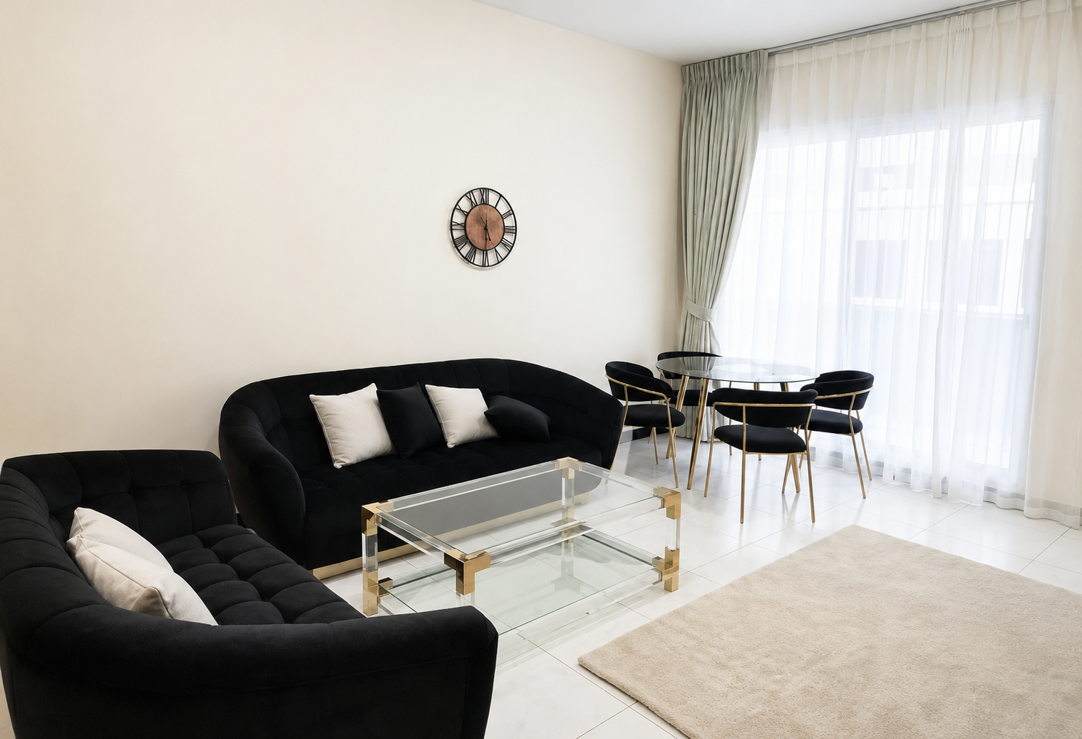 Modern living room with black tufted sofas, glass coffee table, and a round dining set by large windows.