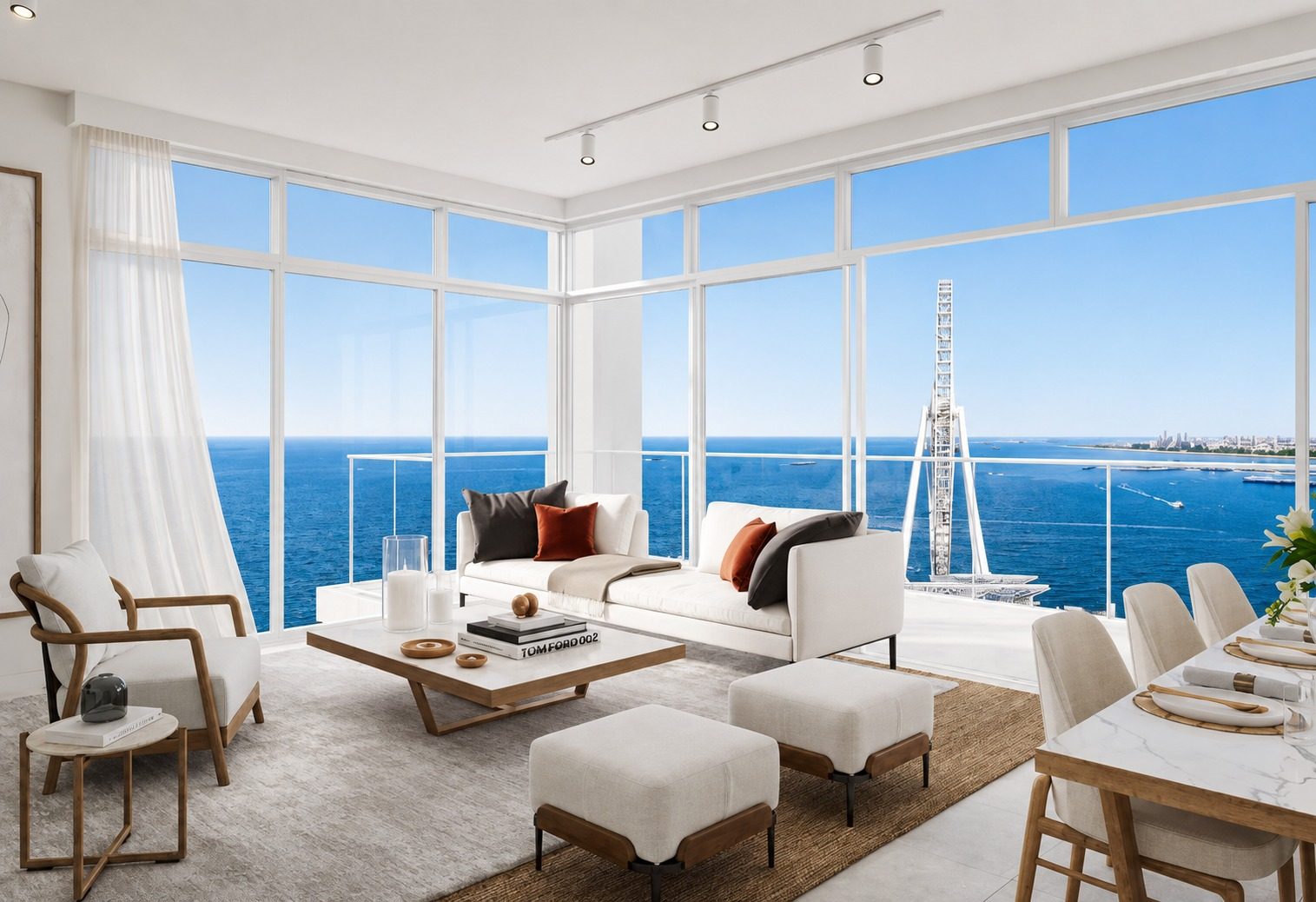 Bright, modern living room with floor-to-ceiling windows overlooking the blue ocean, white sofa and seating area.