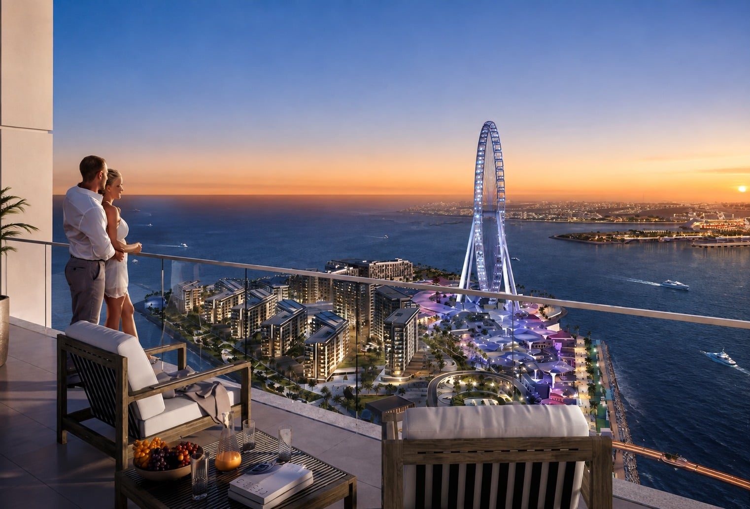 Couple stands on a balcony overlooking a seaside city at sunset, with a large illuminated Ferris wheel in the distance and modern buildings below.